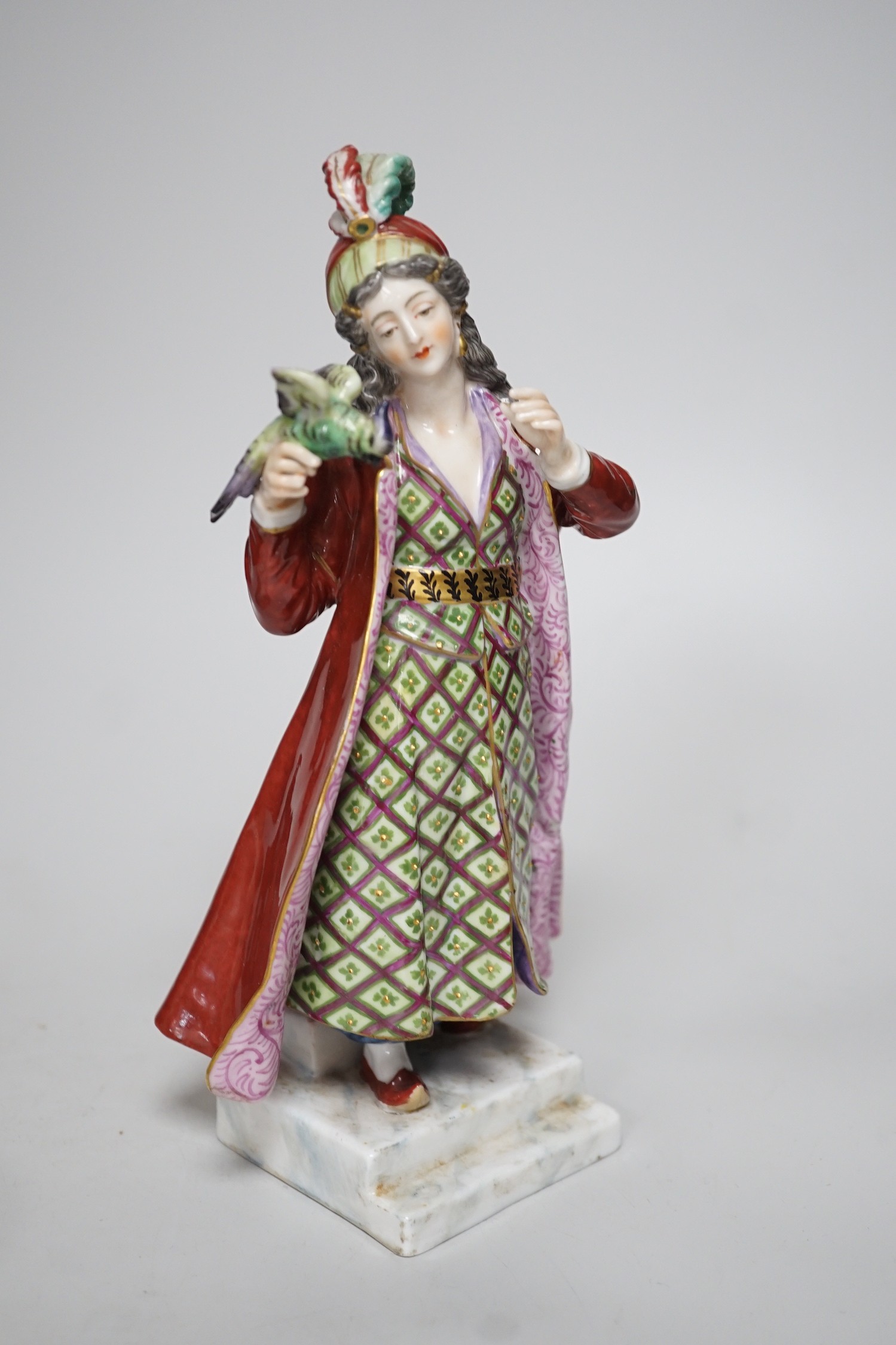 A 19th century German Inkstand with two pots and covers painted with flowers, 24cm wide, and a Volkstedt figure of an eastern European woman holding a bird	